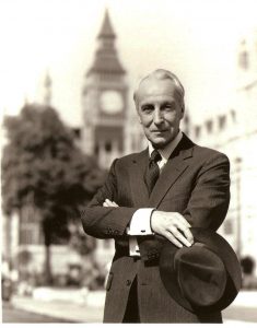 Sempre in bianco e nero, ma ripreso a mezza figura, a braccia conserte, di fronte al Big Ben, vediamo Francis Urquhart, protagonista dell'House of Cards originale. E' piuttosto avanti con l'età, ha i capelli bianchi, e un'espressione sorniona, quasi bonaria.