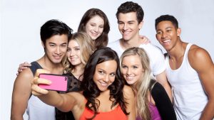 Il cast di Dance Academy si mette in posa per un selfie, dietro hanno uno sfondo bianco