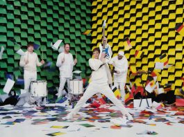 OK Go - Il nuovo sorprendente video Obsession ha come scenografia una parete di 567 stampanti che stampano fogli colorati dietro la band.