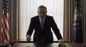 L'immagine è la più simbolica di House of Cards. Alla fine della seconda stagione, il Presidente Underwood sposta la poltrona dietro alla scrivania nella sala ovale, accarezza il pianale in pelle, alza lo sguardo in camera e picchia due colpi di anello sul tavolo. Il gesto è tipico del protagonista, quando raggiunge qualcosa di importante.