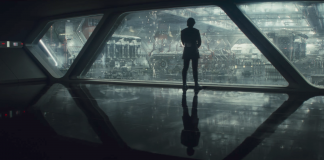 Campo lungo estratto da Gli Ultimi Jedi. Unna campata di trasparacciaio, in un hangar dello Star Destroyer di Kylo Ren, ritratto di spalle mentre guarda l'avanzamento dei lavori sulla nave.