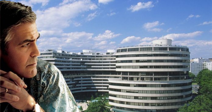 George Clooney in primo piano guarda il palazzo del Watergate. Netflix sta producendo la serie sullo scandalo.
